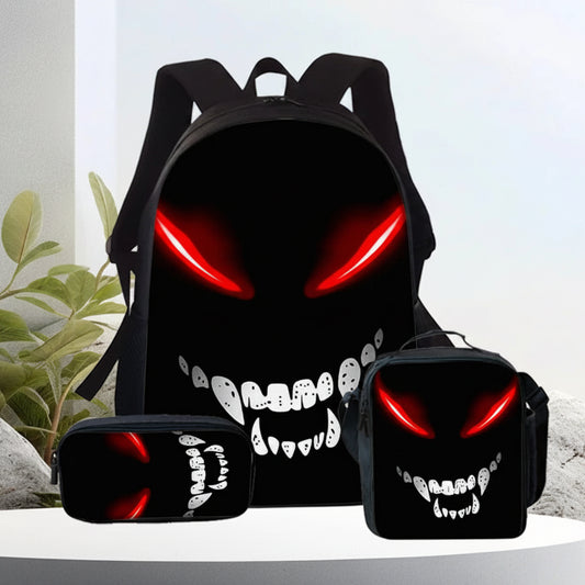 A black backpack set with matching lunch bag and pencil case, all printed with a glowing red eye and white fang grin.