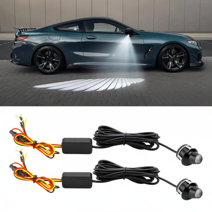 A car side-mounted projector light system shown in two views: a dark teal sports coupe with the projected light beam turned on, and two separate projector units with wiring harnesses below on a white background.