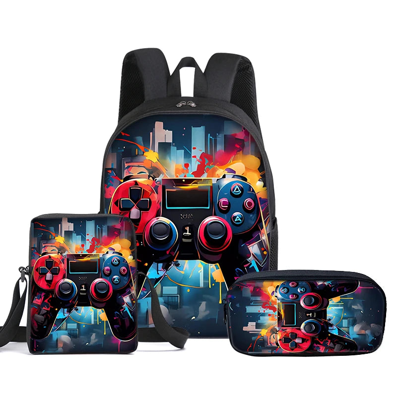 A gaming-themed backpack set with matching accessories, including a backpack, a zippered pouch, and a slim case, all featuring a vibrant graphic print of a video game controller over a city skyline. The backpack is shown in the center, with the matching pouch and case displayed in front on a plain white background.