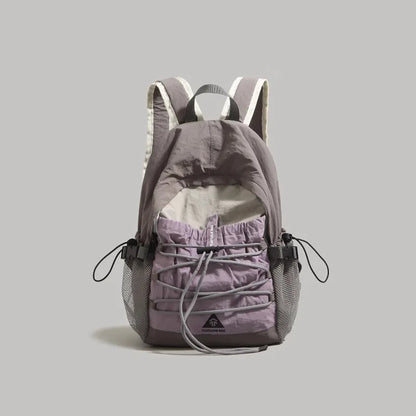 A gray and lavender drawstring backpack with mesh side pockets, shown from the back against a solid gray background.