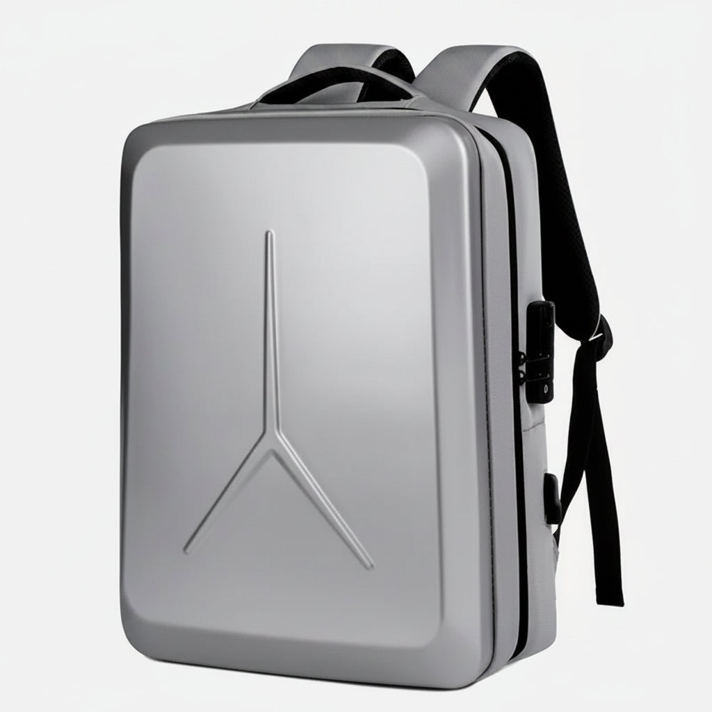 A silver hard-shell laptop backpack with black straps and zipper details, featuring a prominent Y-shaped embossed logo on the front, shown against a plain white background.