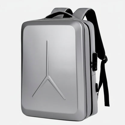 A silver hard-shell laptop backpack with black straps and zipper details, featuring a prominent Y-shaped embossed logo on the front, shown against a plain white background.