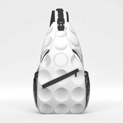 A white sling backpack with a black and white golf ball pattern, featuring black mesh side pockets and a black zipper detail.