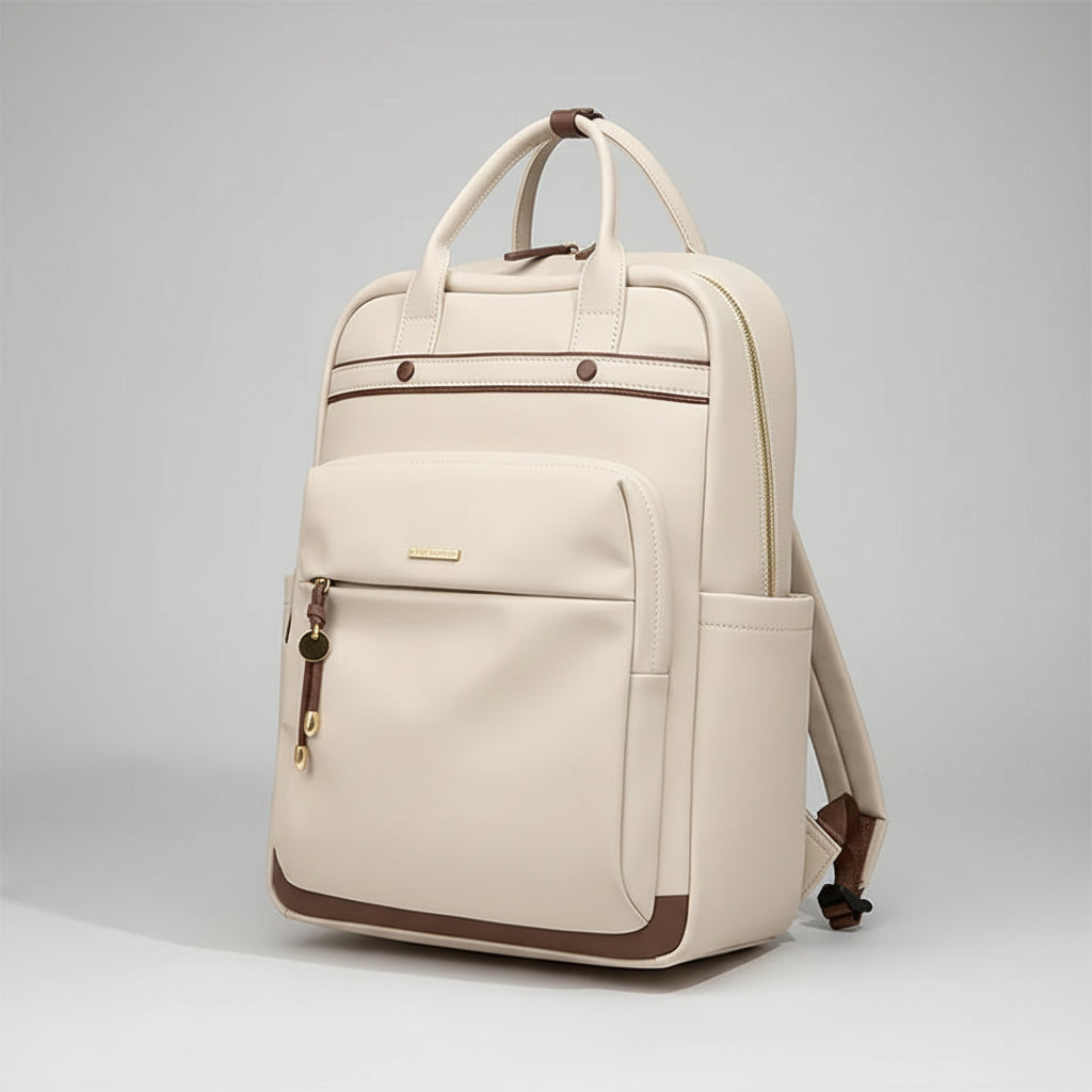 An off-white leather backpack with brown trim and gold-tone hardware, shown on a pink surface against a split white and sage green background. The brand name 'GOLF' is visible in the top left corner.
