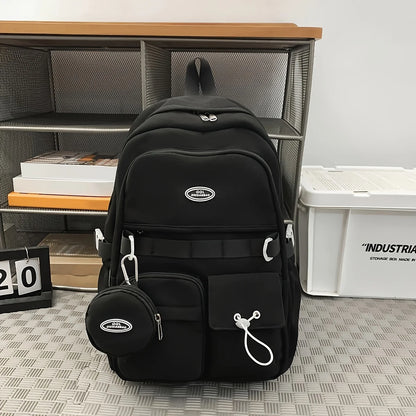 Black backpack with a small round pouch on a gray floor with a metal shelf and white container in the background.