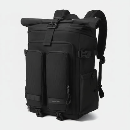 Black backpack with multiple pockets and straps on a light gray background