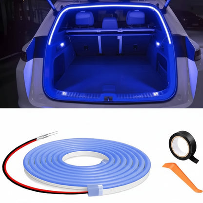 Blue LED strip light set with roll, tape, and tool on a car trunk background