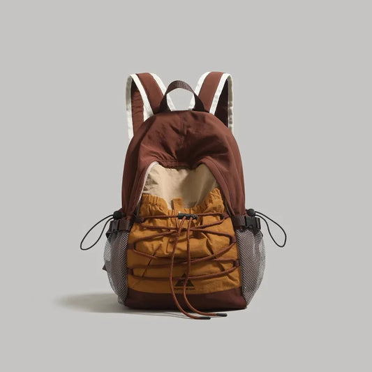 Brown and mustard yellow backpack on a gray background