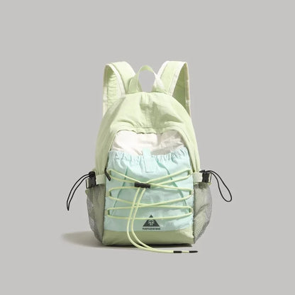 Light green backpack with a smaller bag inside on a gray background