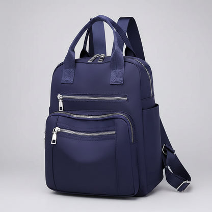 Navy blue backpack with multiple zippers on a white background