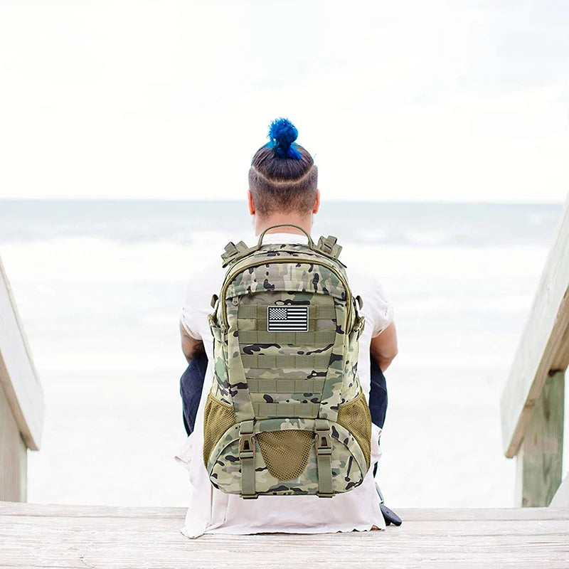 Person sitting on a wooden deck wearing a camouflage backpack with an American flag patch.
